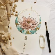 a drawing with watercolors on paper next to a brush and some dried flowers