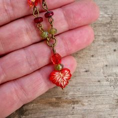 "This fun Boho-inspired necklace brings the warm colors of Autumn to any season. These gorgeous colors should not be limited to just one season a year. For those who look best in Fall and Spring colors, this necklace is for you! The slight differences in the leaf beads make this necklace a naturally unique feel. The larger leaf bead is 10 x 13mm; the smaller beads are 6mm and 3 x 5mm. All items in this series are shown in antique brass but can be made in gunmetal or silver. This necklace is 16 - Red Bohemian Nickel-free Necklace, Bohemian Red Nickel-free Necklace, Red Bohemian Necklace With Lobster Clasp, Bohemian Red Necklace With Lobster Clasp, Czech Glass Dangle Necklaces As Gift, Red Bohemian Beaded Necklace With Lobster Clasp, Handmade Red Nature-inspired Necklace, Brown Heart-shaped Bohemian Necklace, Brown Bohemian Heart Necklaces