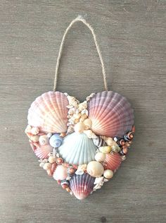 a heart shaped ornament with seashells hanging from it's sides