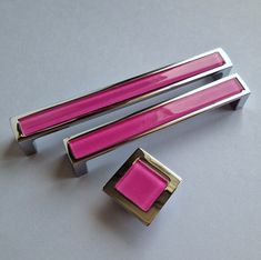 two pink and silver objects sitting on top of a white table next to each other