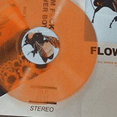 an orange cd with a black and white image of a bee on it's side