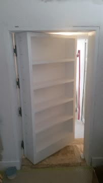 an empty book shelf in the corner of a room with no one on it,