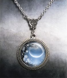 Winter Solstice Art Nouveau necklace ~ Celebrate the Yuletide season with this beautiful image of falling snow and new moon.   The pendant measures 1-3/16" across (30mm) and the artwork is covered by a crystal clear, domed glass cabochon which protects and enhances the image for a truly beautiful effect!   The necklace closes with a lobster clasp and has a 2" extension chain, so an 18" necklace will adjust up to 20", a 21" necklace adjusts up to 23", etc.  If you would prefer to not have the extension chain, please leave us a note at checkout. We have 4 chain lengths available at checkout and custom lengths are also available at no extra charge. Please visit Moon Garden Designs on Etsy for many more unique and beautiful pendant and necklace designs: http://www.moongardendesigns.etsy.com Nickel-free Mystical Round Necklaces, Nickel Free Round Mystical Necklace, Nickel-free Round Mystical Necklace, Round Winter Jewelry Gift, Round Jewelry Gift For Winter, Winter Solstice Art, Solstice Art, Full Moon Necklace, Art Nouveau Necklaces