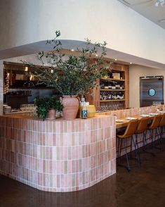 an empty restaurant with tables and chairs in front of the counter, filled with wine bottles