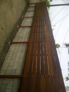 a wooden bench sitting on the side of a building next to power lines and telephone poles