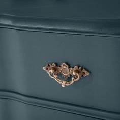 a blue dresser with gold handles and knobs on the drawer handle is seen in this image