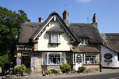 a white and brown house with thatched roof