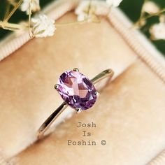 a close up of a ring with a purple stone