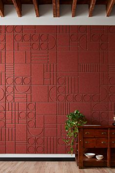 a room with red wallpaper and wooden flooring next to a plant on a table