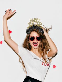 a woman with sunglasses and a crown on her head is posing for a photo in front of hearts