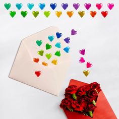 an envelope with hearts coming out of it next to red flowers and rainbow colored confetti