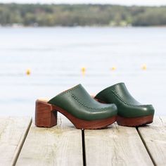 Our Blenda high-heeled clog in deep, forest green is a modern take on the traditional slip-on clog. The decorative stitching brings a unique touch to this stylish clog. With its cushioned, flexible sole, the Blenda clog is both stylish and easy to wear. Designed in Sweden and handmade in Portugal from premium, sustainably-sourced leather. Heel 7.5 cm / 2.95 in Soft, flexible lightweight sole Leather lined Normal fit Green Clogs With Rubber Sole And Round Toe, Green Casual Mules With Wooden Heel, Green Closed Toe Heels With Wooden Heel, Green Clogs With Wooden Heel For Spring, Green Clogs With Rubber Sole And Closed Toe, Casual Green Mules With Wooden Heel, Green Clogs With Leather Sole And Round Toe, Green Mules With Leather Sole And Round Toe, Green Clogs With Removable Insole