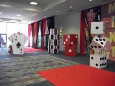 a room filled with lots of dice and playing cards on red carpeted flooring