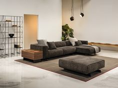 a living room with a large sectional couch and ottoman