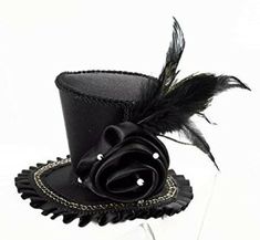 Lovely, black satin, mini Victorian style top hat. Decorated with a pearl studded satin rose, grosgrain ribbon ruffle, gold & black chain pattern trim, and assorted feathers. 2 Clips hold the hat in place. 3" crown, 1 1/2" brim, 6" wide at base. Miniature Hats, Rose Costume, Mini Hats, Rose Hat, Black Top Hat, Steampunk Hat, Fascinator Hairstyles, Flower Fascinator, Mini Top Hat