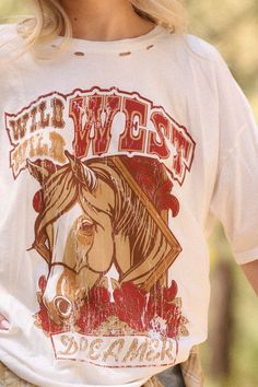 Distressed, garment washed graphic t-shirt. Vintage-style horse graphic with "Wild, Wild West Dreamer" text print. Torn and distressed detailing at neckline, cuffs, and hem. Round neckline. Short sleeves. Drop shoulder. Oversized fit. 100% Cotton. Imported top designed and printed in LA. Model wears size S. Oversize Graphic Tee, Horse Graphic, Wild Wild West, Oversized Graphic Tee, Text Print, Vintage Canvas, Wild West, Oversized Fits, Drop Shoulder