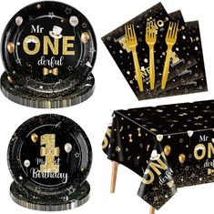 black and gold 1st birthday party supplies including plates, napkins, forks and cake