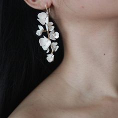 a close up of a person wearing earrings with flowers on them