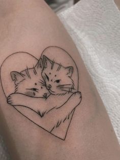 a couple of cats hugging each other with a heart tattoo on their arm and shoulder