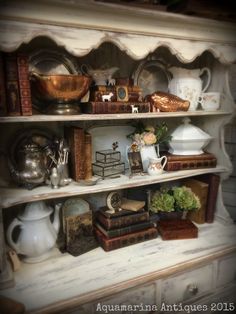 an antique china cabinet with books, vases and other items on it's shelves