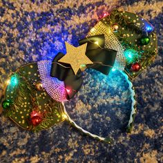 a pair of headbands decorated with lights and bows on top of a carpet