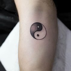 a black and white tattoo on the leg of a person with a yin - yang symbol