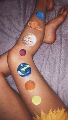 a woman laying on top of a bed covered in lots of different planets and sunflowers