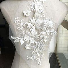 the back of a mannequin with white flowers on it