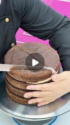 a person cutting into a chocolate cake with a knife