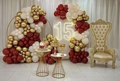 a room with balloons, chairs and tables on the floor in front of a white backdrop