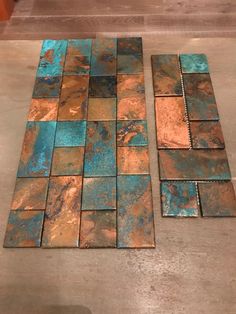 two pieces of metal sitting on top of a floor next to each other with blue and brown tiles