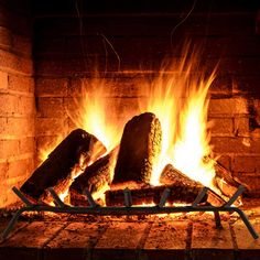 a fire burning in a fireplace with logs