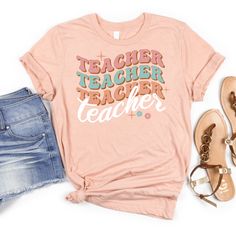 Teach your style a lesson with this Repeat Teacher Pattern Tee! This playful tee features a unique, repeating teacher pattern that's sure to make a statement. Show off your love for teaching in a fun and quirky way with this one-of-a-kind t-shirt. Fun T-shirt With Funny Print For Back To School, Trendy Teacher Appreciation T-shirt For Back To School, Trendy Relaxed Fit Tops For School, Retro Relaxed Fit Tops For School, Trendy Funny Print T-shirt For School, Trendy School T-shirt With Funny Print, Fun T-shirt With Text Print For Back To School, Playful Relaxed Fit T-shirt With Letter Print, Casual Tops With Funny Print