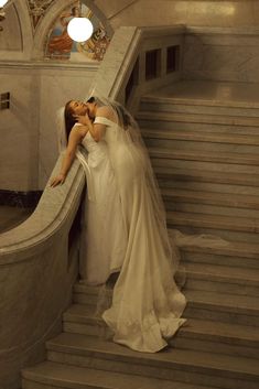 two women in wedding dresses kissing on the stairs