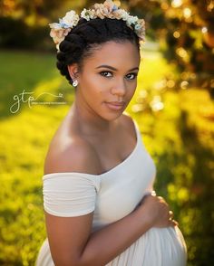 a pregnant woman in a white dress poses for a photo with her hands on her belly