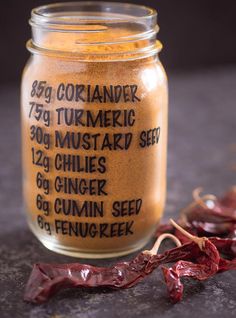 a jar of gourmet chili seasoning next to dried peppers