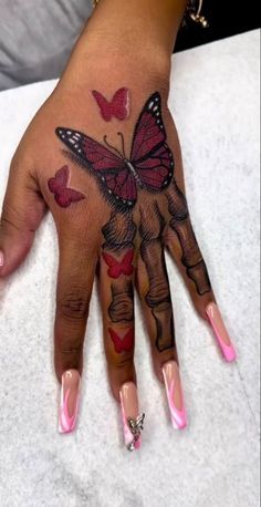 a woman's hand with butterflies on it and pink nail polishes in the shape of hearts