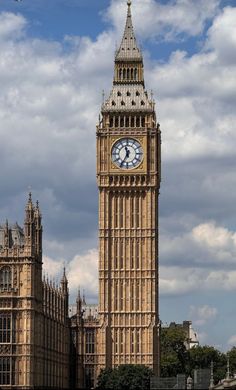 the big ben clock tower towering over the city of london on a partly cloudy day