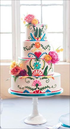 a multi - tiered cake decorated with colorful flowers