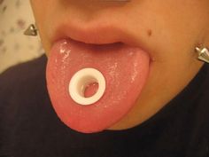 a woman sticking her tongue out with an o ring on it's end,