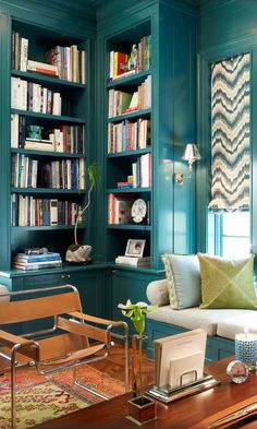 a living room filled with furniture and bookshelves covered in lots of bookcases