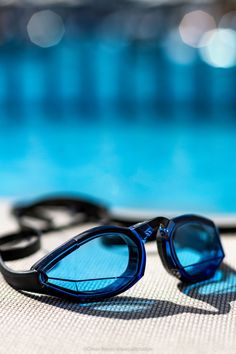 some sunglasses are laying on the ground near a swimming pool