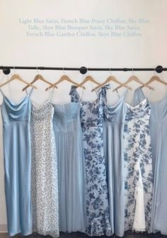 several dresses hanging on a rack in front of a sign