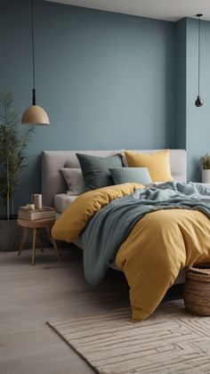 a bed with yellow and blue sheets in a room next to a table, potted plant and lamp