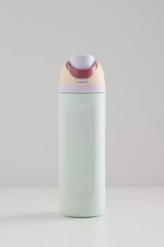 a pastel green and pink insulated water bottle sitting on a white countertop