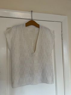 "women's hand knitted sleeveless off white chunky sweater jumper  Made of wool but not sure exactly which kind perhaps an acrylic mix Rib knit on the hem and armholes and neckline  can be worn by either men or women  size M/L 21\" armpit to armpit across the front although there is some stretch  25\" long from neck at the back to hem  can also be worn oversized  Excellent preloved condition" White Chunky Knit V-neck Top, White Textured Knit V-neck Sweater Vest, Chic White Crew Neck Sweater Vest, Sleeveless Knitted Cotton Sweater, Trendy Fitted Textured Knit Sweater Vest, Casual Fitted Textured Knit Vest, Chic White Cotton Sweater Vest, White Knit V-neck Vest, Sleeveless Textured Knit Cotton Sweater