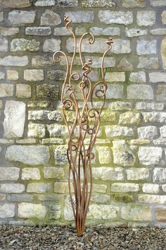 a tall metal planter in front of a brick wall