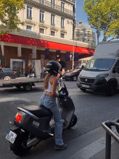 a woman on a motor scooter in the street