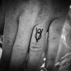 a person's hand with a small tattoo on it