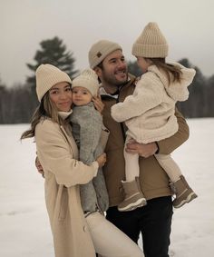 a man and woman holding two children in the snow